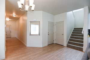 Interior space with a chandelier and light hardwood / wood-style flooring