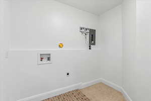 Washroom with hookup for a washing machine, tile flooring, and electric dryer hookup