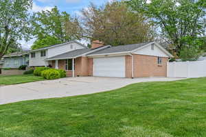 Tri-level home with a front lawn and a garage