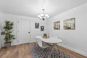 Dining area featuring hardwood / wood-style flooring and an inviting chandelier