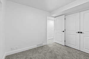 Unfurnished bedroom with light carpet and a closet