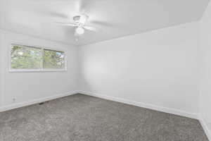 Carpeted empty room with ceiling fan