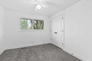 Carpeted spare room featuring ceiling fan