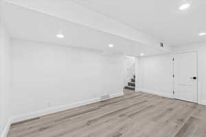 Basement with light hardwood / wood-style flooring