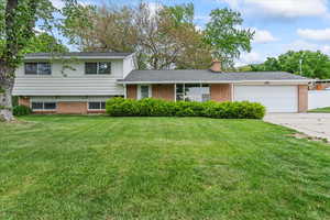 Split level home featuring a garage and a front yard