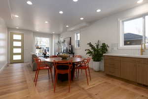 Dining area with sink and light wood-type flooring