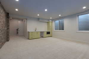 Basement featuring sink and light carpet