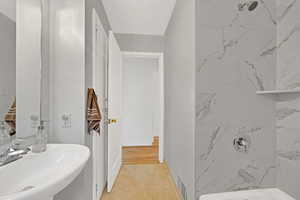 Bathroom with tiled shower / bath, tile flooring, and sink