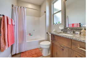 Full bathroom featuring vanity, toilet, and shower / tub combo