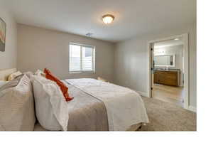 Bedroom featuring sink, ensuite bath, and light wood-type flooring