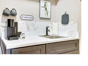 Bathroom with vanity and tasteful backsplash