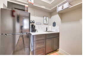 Kitchen featuring stainless steel refrigerator, sink, and light hardwood / wood-style flooring