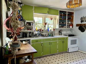 Kitchen featuring sink, electric range, and green cabinets