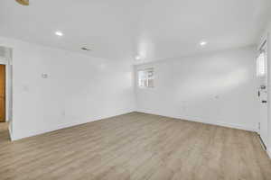 Empty room with light hardwood / wood-style flooring