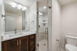 Bathroom featuring vanity, toilet, and a shower with shower door