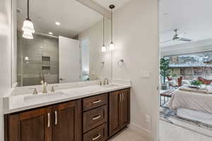 Bathroom with ceiling fan, tile patterned flooring, vanity, and an enclosed shower