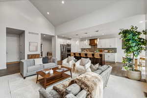 Living room with hardwood / wood-style floors, high vaulted ceiling, and sink