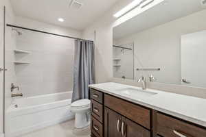 Full bathroom with vanity, toilet, and shower / bath combo with shower curtain