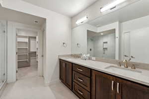 Bathroom featuring tile patterned floors, vanity, and an enclosed shower