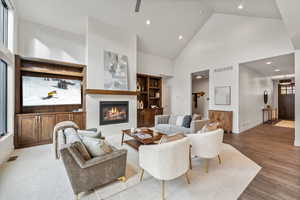 Living room with hardwood / wood-style flooring and high vaulted ceiling