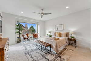 Carpeted bedroom featuring ceiling fan