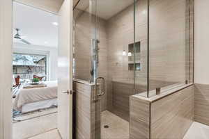 Bathroom featuring tile patterned flooring, ceiling fan, and a shower with shower door