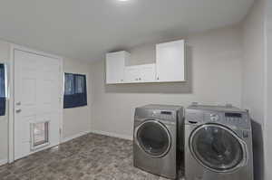 Laundry area featuring tile flooring, cabinets, and washer and dryer