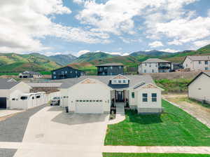 View of front of house with a front lawn, a garage, and a mountain view