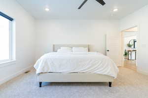 Bedroom featuring ceiling fan, carpet floors, and multiple windows