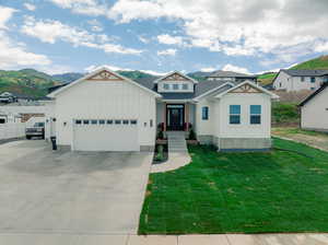 View of front of property featuring a garage, a mountain view, and a front lawn