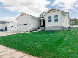 View of front facade featuring a garage and a front lawn