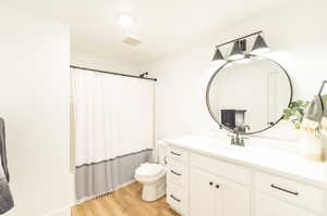 Bathroom with LVP flooring, toilet, and vanity