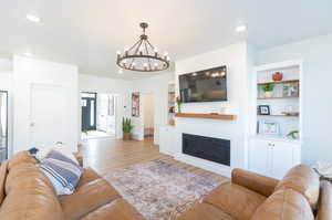 Living room with light LVP floors and a chandelier