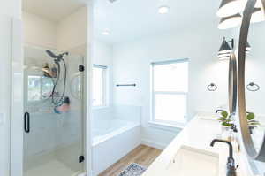 Bathroom featuring LVP flooring, plus walk in shower, and dual bowl vanity