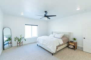 Bedroom with ceiling fan and light colored carpet