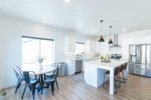 Kitchen with stainless steel appliances, a center island, and light VLP flooring