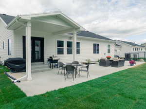 Back of property featuring a patio, an outdoor hangout area, and a yard