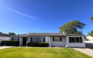 Ranch-style home featuring a front lawn