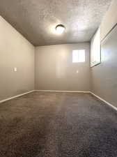 Bedroom featuring a textured ceiling, a closet, and carpet floors