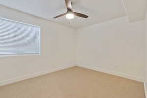 Unfurnished room featuring carpet and ceiling fan