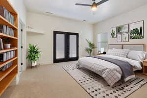 Carpeted bedroom with access to exterior, ceiling fan, and french doors