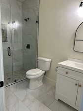 Bathroom with tile patterned flooring, toilet, vanity, and a shower with shower door