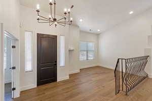 Entryway featuring light hardwood floors, a healthy amount of sunlight, and a chandelier