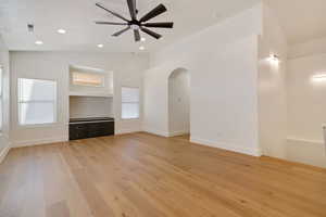 Great room featuring vaulted ceiling, ceiling fan, light hardwood / wood floors, and built in shelves