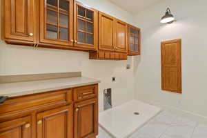 Laundry room with cabinets, light tile flooring, electric  and gas dryer hookup, and washer hookup