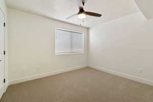 Carpeted empty room featuring ceiling fan