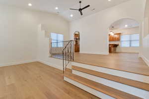 Living room, light wood flooring, and ceiling fan