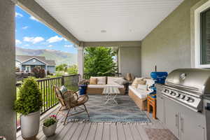 Deck featuring an outdoor living space, a mountain view, and grilling area