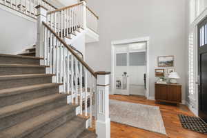 Foyer entrance featuring a towering ceiling and hardwood / wood-style floors