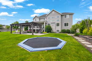 Back of house with a pergola, a patio area, and a yard